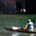 Kayaker looking into a sea cave on Lake Superior.