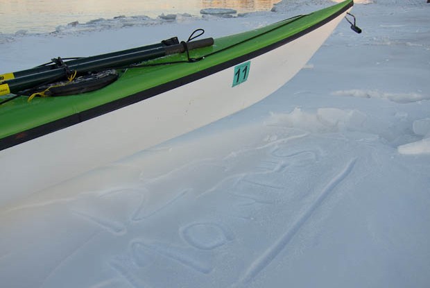 Kayak and 12 months etched out of snow.