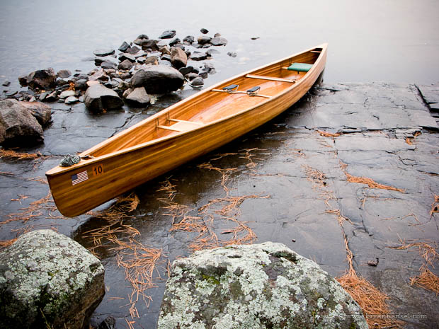wood canoe sits on rain socked rocks in the Boundary Waters. BWCA 